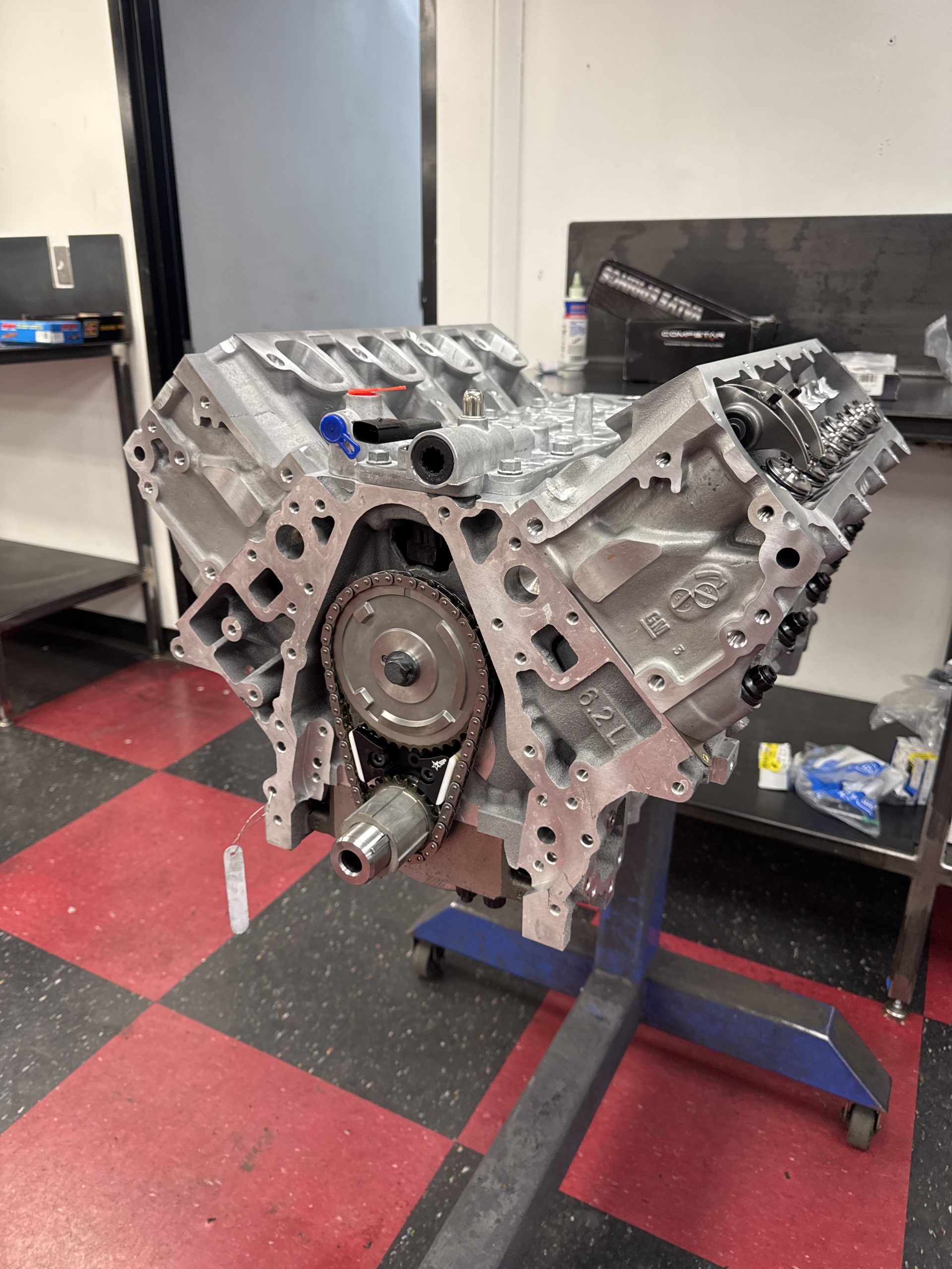 Aluminum Chevy small-block V8 crate engine on a stand in a clean engine shop, illustrating LT1 vs LT4 performance build differences.